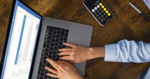 Profissional usando notebook e calculadora para organizar a contabilidade médica e o planejamento financeiro